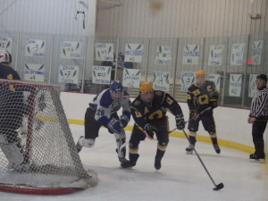 Queensbury's Evan Conlin '15 and Saratoga's Elliott Hungerford '16 race for the puck as it moves behind the Queensbury net during the third period.